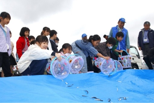 小学生と鮎の放流